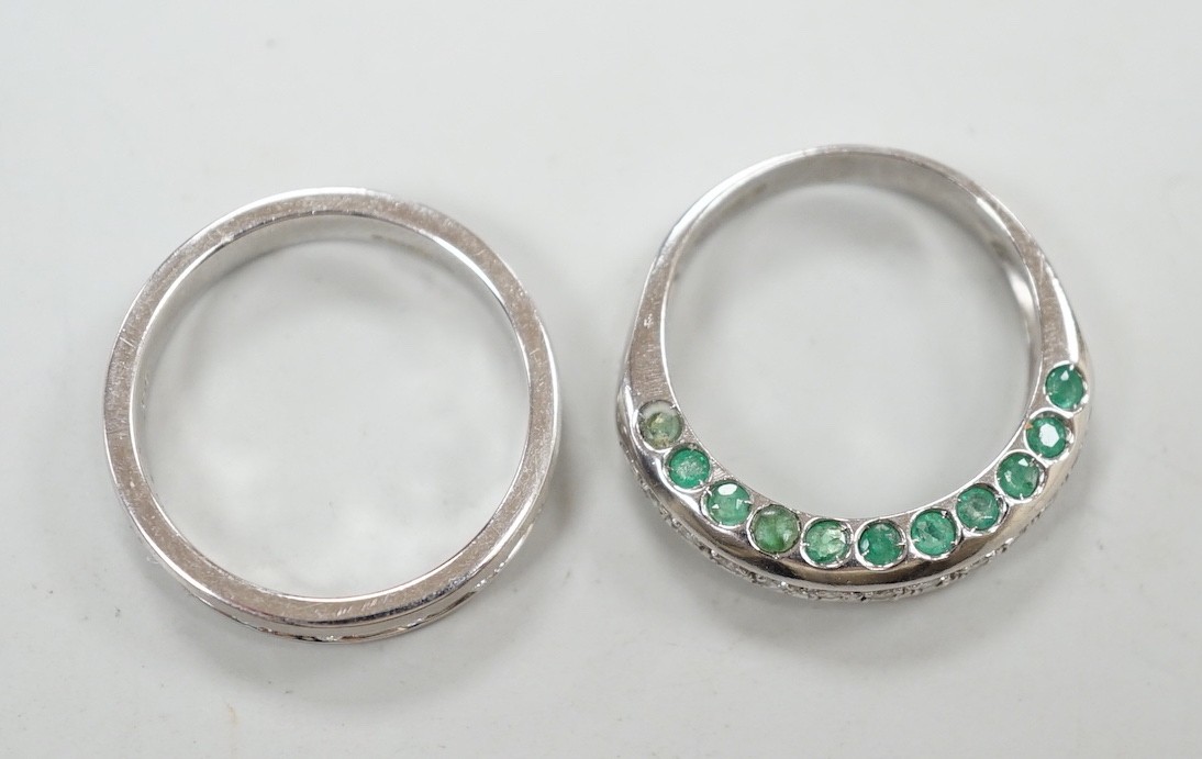 An unusual modern 18ct white gold and thirteen stone diamond chip set half hoop ring, each side of the settling set with ten emeralds, size L and one other modern 18ct white gold and diamond chip set ring, size N, gross